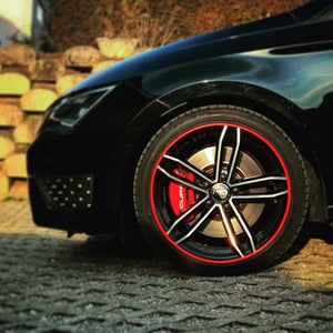 Red rim protector wheel guards on the edge of a black Volkswagen GTI wheel for ATAM Auto.