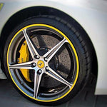 Yellow rim protector wheel guards on the edge of a white Ferrari wheel for ATAM Auto.